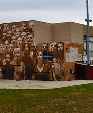 Image shows the exterior of Murphy Rec Center, one of the walls has a sepia tone mural depicting a diverse group of neighbors in a realistic style. Photo credit: N Giovannucci 